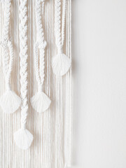 Decoração de parede em artesanato macramé com franjas em fundo branco