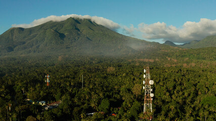 Antennas and microwaves link dishes of mobile phone network and TV transmitter on telecommunication towers with mountains and rainforest. Camiguin, Philippines - obrazy, fototapety, plakaty
