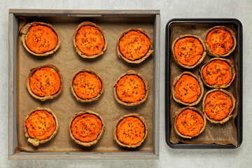 Carrot pies top view in a tray. Pastry with carrot and potato filling with caraway seeds. Rye flour homemade pastry.