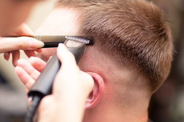 Haircut of the head. Trimmer work. Men's haircut. Hair cutting close-up.