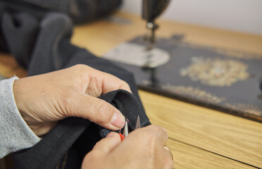 Close-up view of sewing process. Female hands stitching with a vintage sewing machine. Selective...
