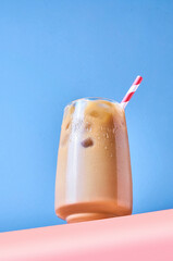 Iced Coffee with Milk in Tall Glasses on Pink Table and Blue Background. Trendy Hero View