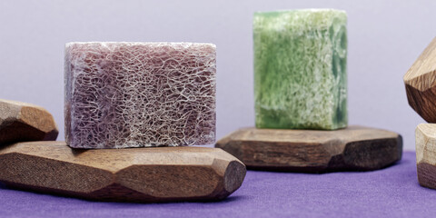 Soap with loofah sponge inside. Purple and green glycerin soaps with natural scrub. - obrazy, fototapety, plakaty