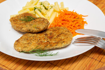 Fried chicken mince cutlet,pasta and carrot salad on a white plate.