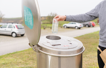 Man recycling glass. Glass recycling point. Hand with glass bottle.
