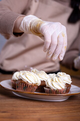 making cupcakes with cream close-up with the hands of the chef