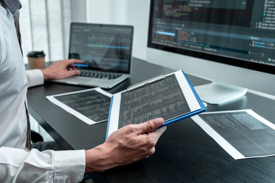 Young Programmer working in software javascript computer in IT office, Writing codes and data code website and coding database technologies to find solution to problem