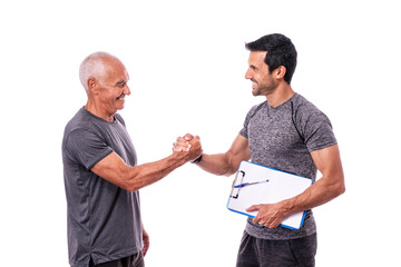 Elderly male client shaking hands in greeting to fitness trainer before training. On a white...
