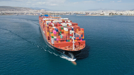 Aerial drone photo of truck size container cargo vessel cruising in deep blue Saronic gulf near commercial port of Piraeus, Attica, Greece - obrazy, fototapety, plakaty
