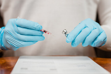 Arzt beim Aufziehen einer Spritze für eine Corona Impfung