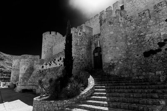 Views of the walls of Atalaya Castle in the town of Villena in black and white.