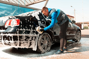 Fototapeta na wymiar The man washing his car on self-service car wash. Express Car Wash
