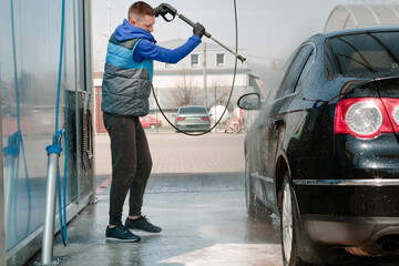The man washing his car on self-service car wash. Express Car Wash