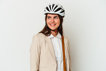 Young caucasian woman riding a bicycle to work isolated on white background looks aside smiling, cheerful and pleasant.