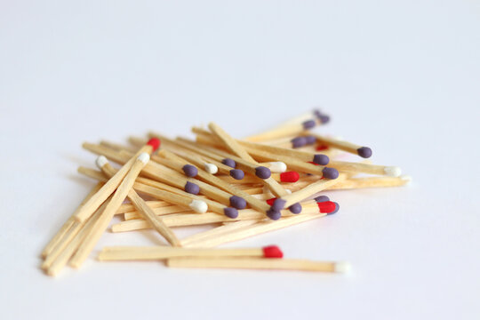 Scattered matches of different colors on a white background