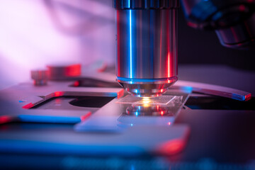Toned photo of a backlit microscope lens in a science laboratory