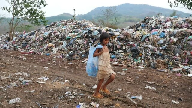 Poverty Kid Walking With Garbage Bag
