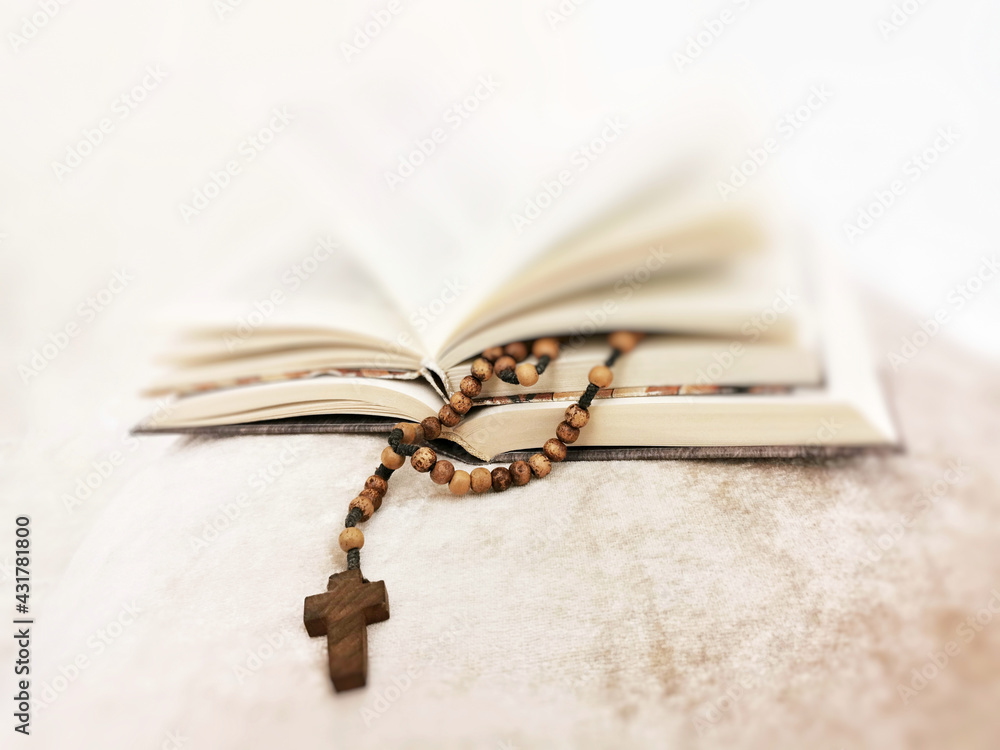 Poster A selective focus shot of a wooden cross necklace with books in the background