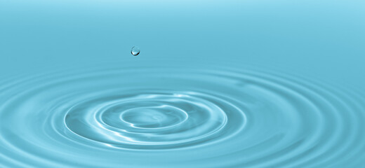 Naklejka na ściany i meble Drop of water drop to the surface. Waves on the surface of the water from a collision