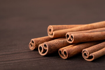 Cinnamon sticks on brown table, bark of aroma tree. Copy space, close up, isolated photo.