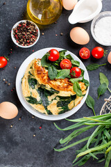 Frittata made of eggs, cheese and spinach salad. Frittata - italian omelet on a plate on a gray background. Ketogenic, keto food, menu recipe, top view