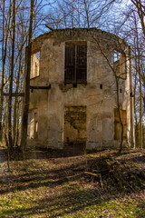 The ruin of a circular building between trees with fallen leaves, Czech republic.