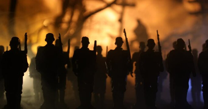 War Concept. Military silhouettes fighting scene on war fog sky background, World War Soldiers Silhouette Below Cloudy Skyline At night. German soldiers in ranks. Selective focus
