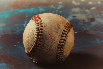 Fototapeta na wymiar old vintage baseball closeup with blurred blue background for sport nostalgia.