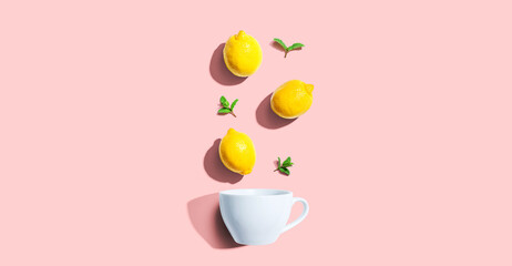 Fresh yellow lemons with tea cup overhead view