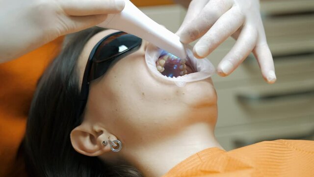 Doctor, dentist makes a 3D scan of the teeth of a female patient, for treatment, patient's visit to the dental clinic