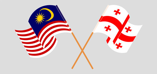 Crossed and waving flags of Malaysia and Georgia