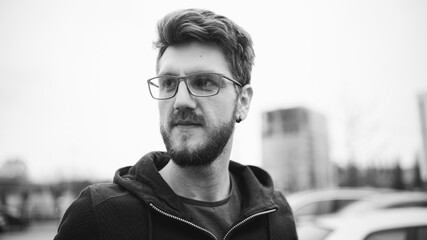 Grayscale portrait of a young Caucasian male wearing glasses
