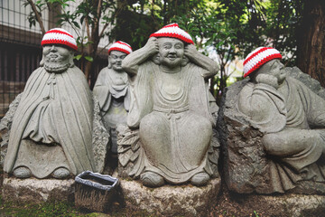 Detail of Buddha statues with knitted hat offerings at the temple Diasho-in in Miyajima, Hiroshima,...