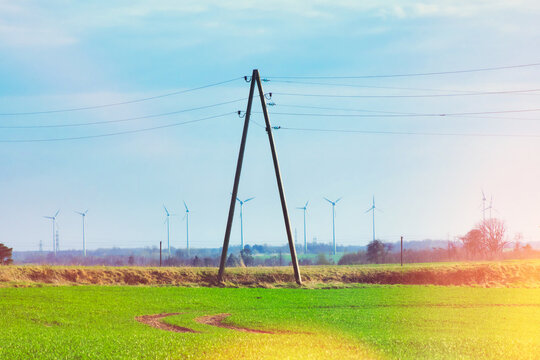 Wooden pole of power line on the background of wind turbines. Turbine Green Energy Electricity Technology Concept.