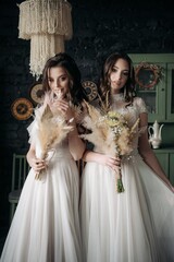 Two young brides in the kitchen in light dresses. Boho style.