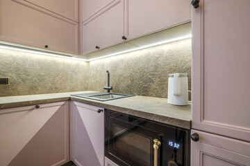 Interior of the modern luxure kitchen  in studio apartments in minimalistic style with light pink color
