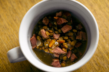 Mug with brown lentils and smoked meat.