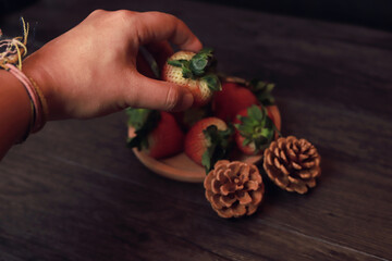 Pick up the strawberries in the wooden tray.