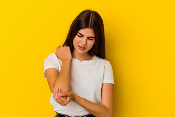 Obraz premium Young caucasian woman isolated on yellow background massaging elbow, suffering after a bad movement.
