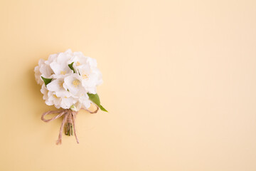 Top view of a jasmine bouquet on a biege background with copy space. Summer or spring greeting card
