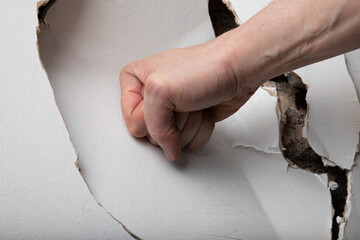 The angry man hits the wall and breaks it