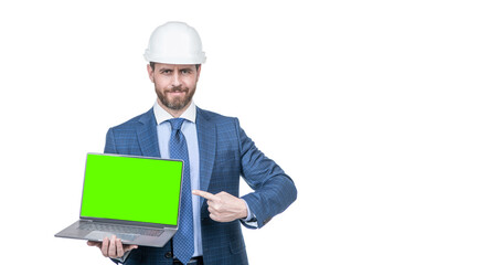 man in suit and safety helmet pointing finger on green screen of computer copy space, advertisement.