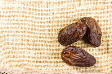 Big luxury dried date fruit on a linen napkin, kurma ramadan kareem concept, close up.