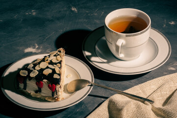 Still life - layered homemade sponge cake and a cup of black tea in a white dish, and a linen...