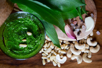 Wild leek pesto with ramson, cashew and pine nuts in a glass jar on a wooden table