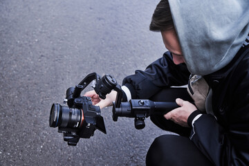 Video camera operator working with professional equipment close up