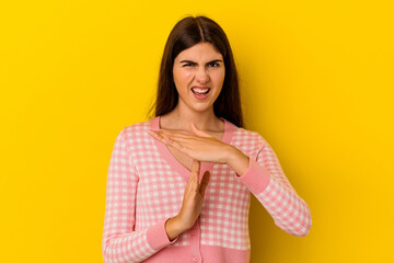 Obraz premium Young caucasian woman isolated on yellow background showing a timeout gesture.