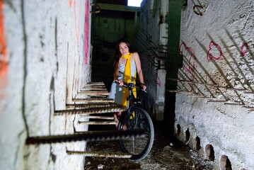 Fototapeta na wymiar The girl on a bicycle in an abandoned room