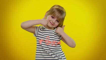 Girl raises thumbs up. Little blonde teen kid child agrees with something, gives positive reply...