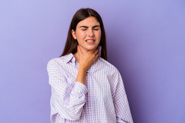 Fototapeta premium Young caucasian woman isolated on purple background suffers pain in throat due a virus or infection.